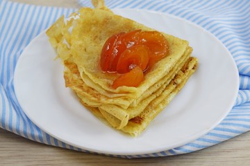 Wall Mural - Delicious hot pancakes with apricot jam on a white plate.