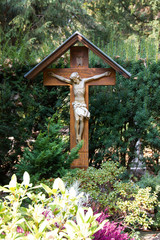 Wooden crucifix that is used as a tombstone in a Catholic Christian part of Germany on a cemetery. Concept of belief and life after death.