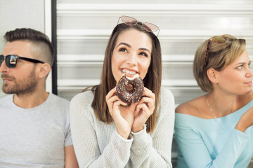 Happy young woman eating donut