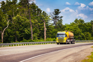 Wall Mural - Yellow truck with tank semi-trailer on a road