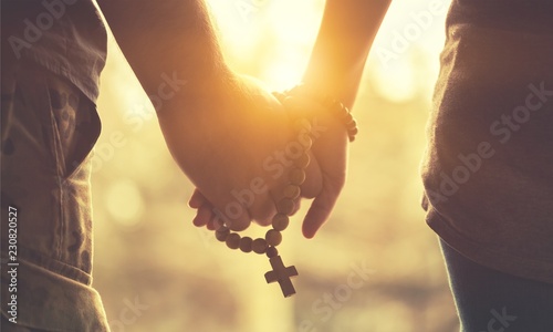 Fotografía Couple praying together. Holding rosary in hand.