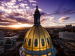 Aerial/Drone photograph of a sunset over the Colorado state capital building.  Capital city of Denver.  The Rocky Mountains can be seen on the horizon
