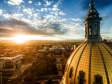 Aerial/Drone Photograph Of A Sunset Over The Colorado State Capital Building.  Capital City Of Denver.  The Rocky Mountains Can Be Seen On The Horizon