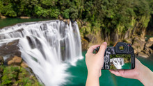Woman Hold Digital Camera On Waterfall View 1