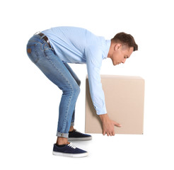 Full length portrait of young man lifting heavy cardboard box on white background. Posture concept