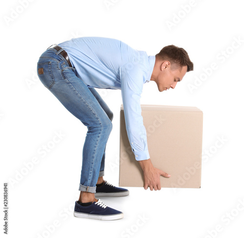 Fotomural Full length portrait of young man lifting heavy cardboard box on white background
