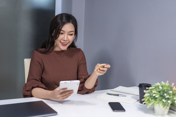 Sticker - happy woman using digital tablet for online shopping with credit card