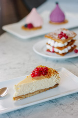 Wall Mural - Cheesecake with red currant berries on white plate.