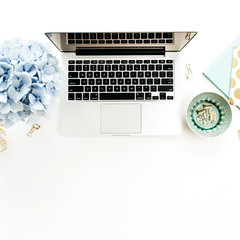 Wall Mural - Modern home office desk with laptop, hydrangea flowers bouquet, accessories on white background. Flat lay, top view.