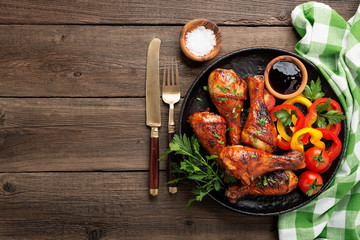 Wall Mural - Grill chicken legs. Grilled chicken legs BBQ with sauce, parsley and tomato.