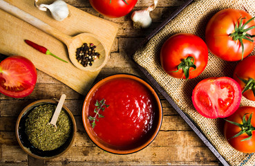 Tomatoes and tomato paste on a rustic wooden table