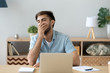 © fizkes - Exhausted or bored male sitting at the desk in office room. Worker or student man yawning covering mouth with hand, feels tired after hard working day. Fatigue lack of energy and overworking concept
