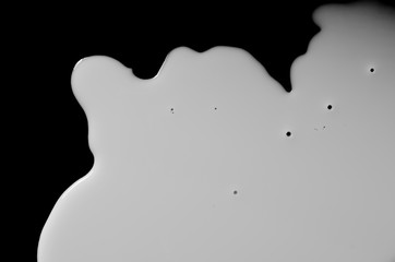 Wall Mural - Spilled milk puddle isolated on black background and texture with clipping path, top view