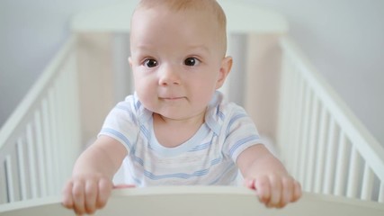 cute baby standing in her crib at home. close-up shot