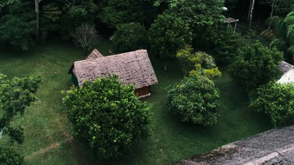 Wall Mural - aerial drone footage of a rainforest village settlement inside the national park with traditional buildings