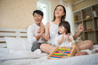 © Johnstocker - Happy child with parents playing in the bed at home