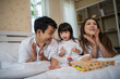 © Johnstocker - Happy child with parents playing in the bed at home
