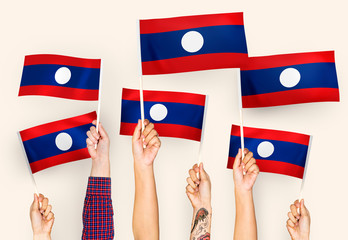 Wall Mural - Hands waving flags of Lao PDR