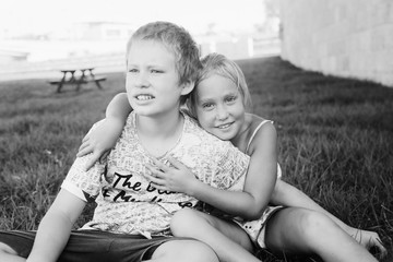 Portrait of happy 7 years old girl with her 10 years old autistic brother outdoors