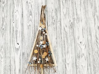 Wooden hand made Christmas tree of twigs, berries and stars close-up. Interior decorative Christmas tree on a wooden background