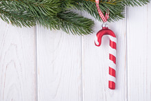 Merry Christmas And Happy New Year. Christmas Decorations Glass Candy Cane And Christmas Tree Branch. Free Space