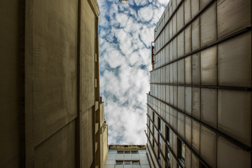 Wall Mural - buildings urban back street corner view from below foreshortening with sky 