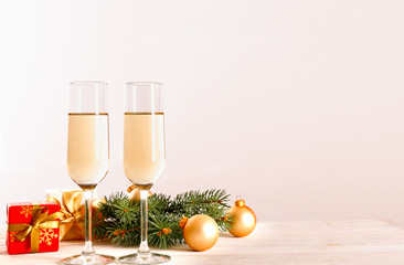 Beautiful christmas composition with two glasses of sparkling wine, decorations on wood textured table. New year's eve tradition to celebrate with champagne. Close up, copy space, background.