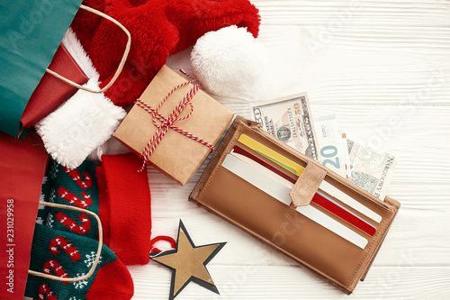 Christmas Shopping And Sales Concept Credit Cards And Money In Wallet Paper Bags With Clothes Stockings Gift Boxes Jewelry On White Rustic Background Seasonal Advertising And Sale Buy This Stock Photo