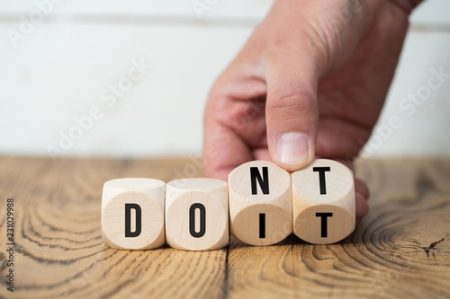 Fotografie, Obraz Hand turns two cubes, changing the word "don't" to "do it"