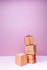 Wall Mural - Craft cardboard gift boxes on the solid pink background. Holiday and gift concept