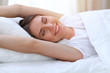 © rogerphoto - Beautiful young and happy woman stretching hands while lying in bed comfortably and blissfully smiling befor wake up in a morning. Sleeping concept