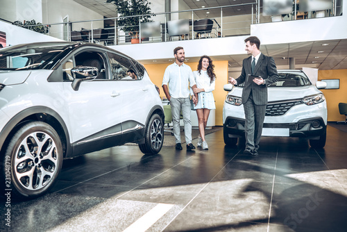 Cuadros en Lienzo Sales manager helping young couple to choose a new car