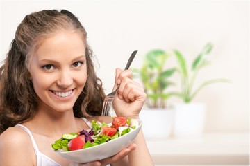 Wall Mural - Young woman with bowl of salad on