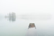 © Tiina Törmänen - Reflection of trees and a pier sticking out of the water on a foggy day