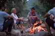 © .shock - young friends relaxing around campfire
