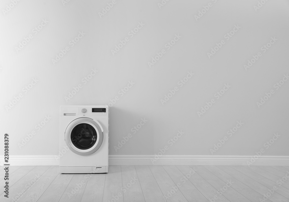 Washing machine near white wall, space for text. Laundry day - obrazy, fototapety, plakaty 