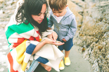 a mother and son exploring on the beach