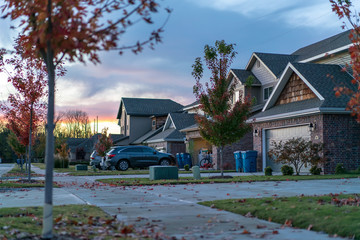 living in residential housing neighborhood street at sunset in bentonville arkansas