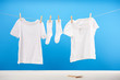 clean white socks and t-shirts hanging on clothesline on blue