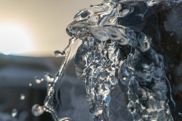 Wall Mural - Beautiful abstract image of the sun shining through an ice sculpture on a frozen mountain stream - fire and ice, light and shadow 