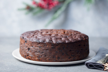 Christmas fruit cake, pudding on white plate. Traditional dessert. Close up.