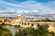 View of Mezquita, Catedral de Cordoba, across the roman bridge on Guadalquivir river. A former Moorish Mosque that is now the Cathedral of Cordoba, Mezquita is a UNESCO World Heritage Site.