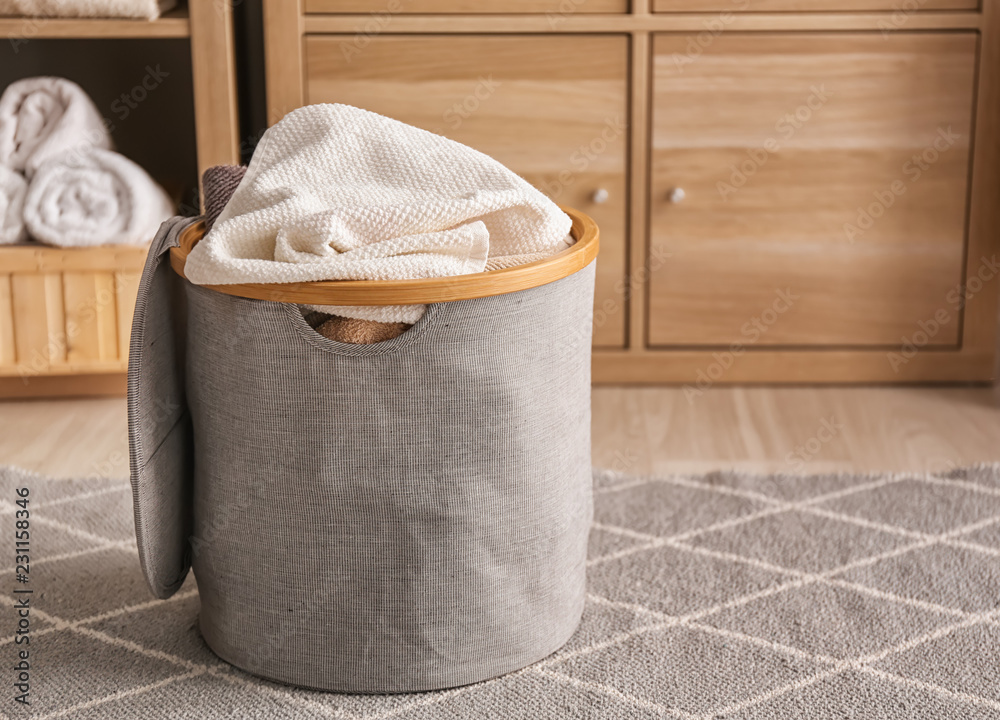Laundry basket with dirty towels on floor in bathroom