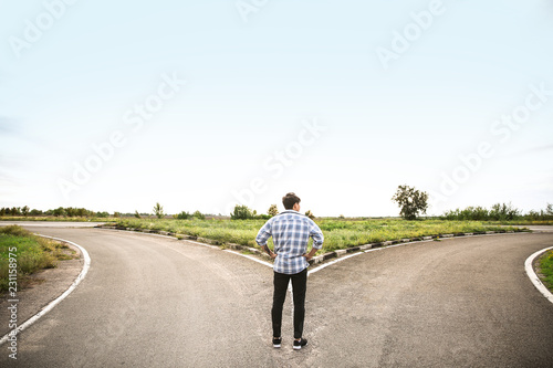 Cuadros en Lienzo Young man standing at crossroads. Concept of choice