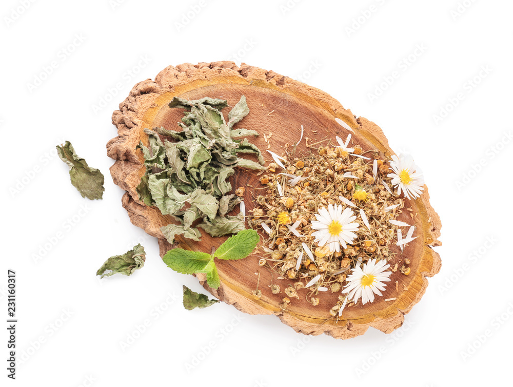 Wooden stand with dried chamomile flowers and mint on white background