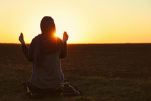 Young Muslim Woman Praying Outdoors At Sunrise