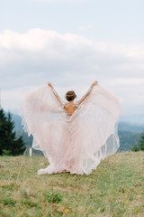 Wall Mural - whirling bride holding veil skirt of wedding dress at pine forest