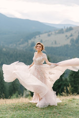 Wall Mural - whirling bride holding veil skirt of wedding dress at pine forest