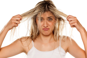 desperate blond woman with messy wet hair on white background