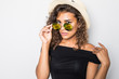 © F8  \ Suport Ukraine - Cheerful curly girl in sunglasses and straw hat laughing on white background. Portrait of chilling tanned woman in summer clothes.